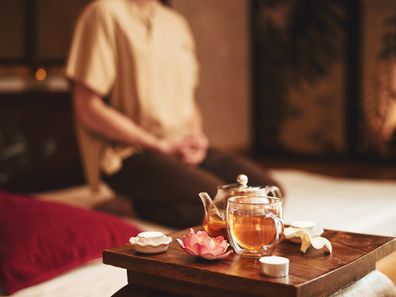Ein Mann meditiert während einer Teezeremonie für völlige Einheit zwischen Körper und Geist.