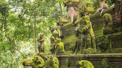 Ein Tempel im Affenwald mit Statuen und echten Affen darauf.