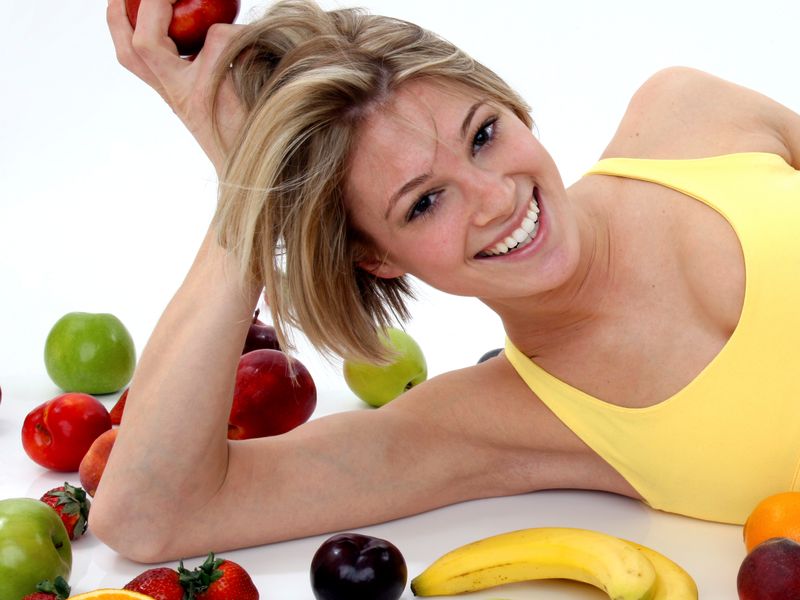 Женщина лежит на столе с фруктами