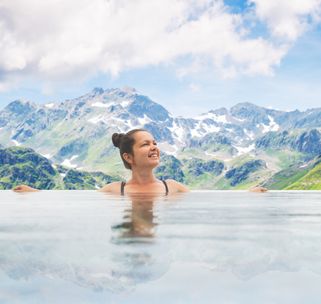 Frau im Pool vor Bergpanorama