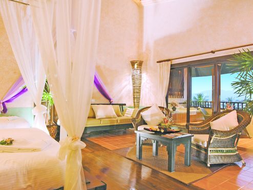 Ein schön eingerichtetes Zimmer mit Himmelbett in einem der Ayurveda Hotels