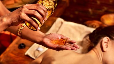 Einer Frau erhält eine Ayurveda-Massage mit erwärmtem Pflanzenöl