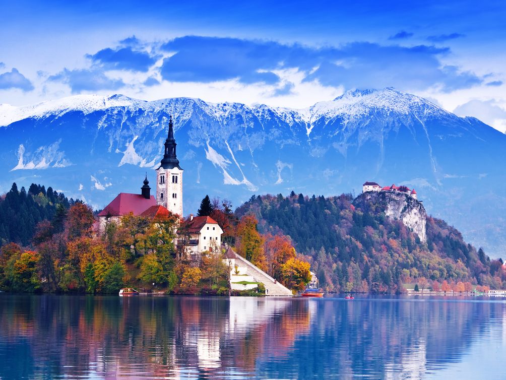 Eine Kirche thront auf einer kleinen Insel inmitten des Sees Bled am Fuße der Alpen