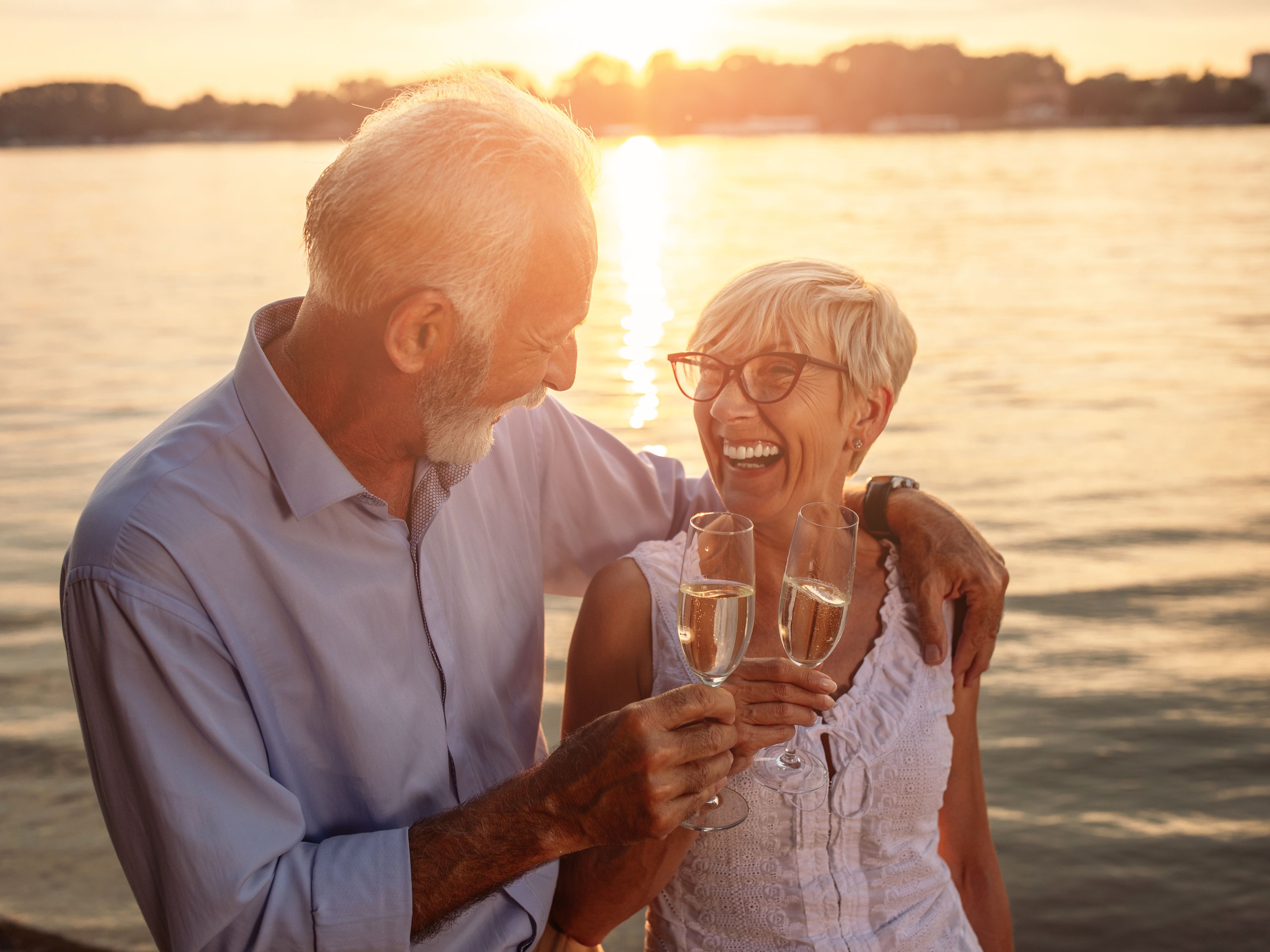 Senioren Pärchen trinkt Sekt am See