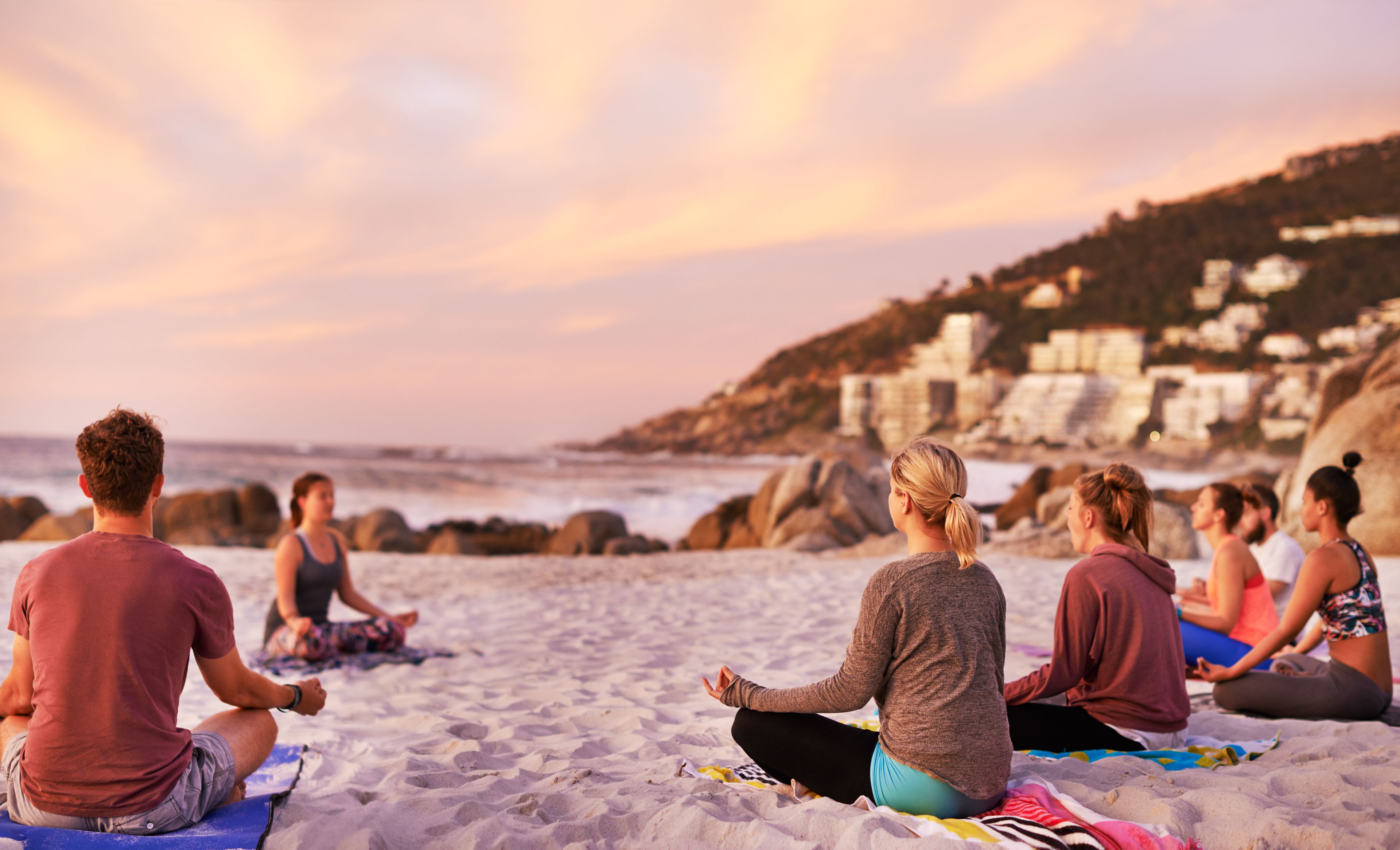 Eine Gruppe von Menschen bei einer Yogastunde am Strand 