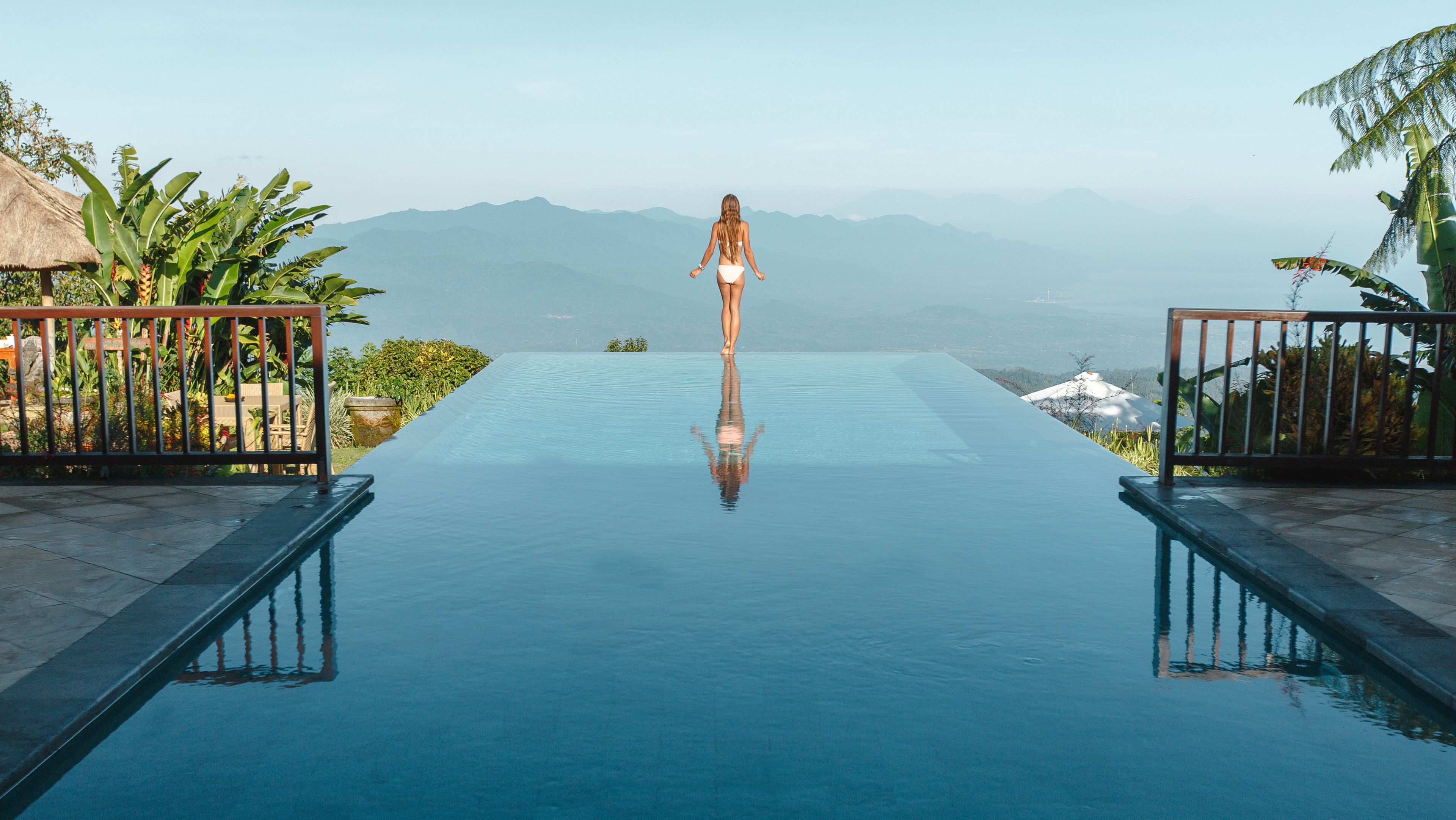 Woman relaxing in infinity pool in Bali