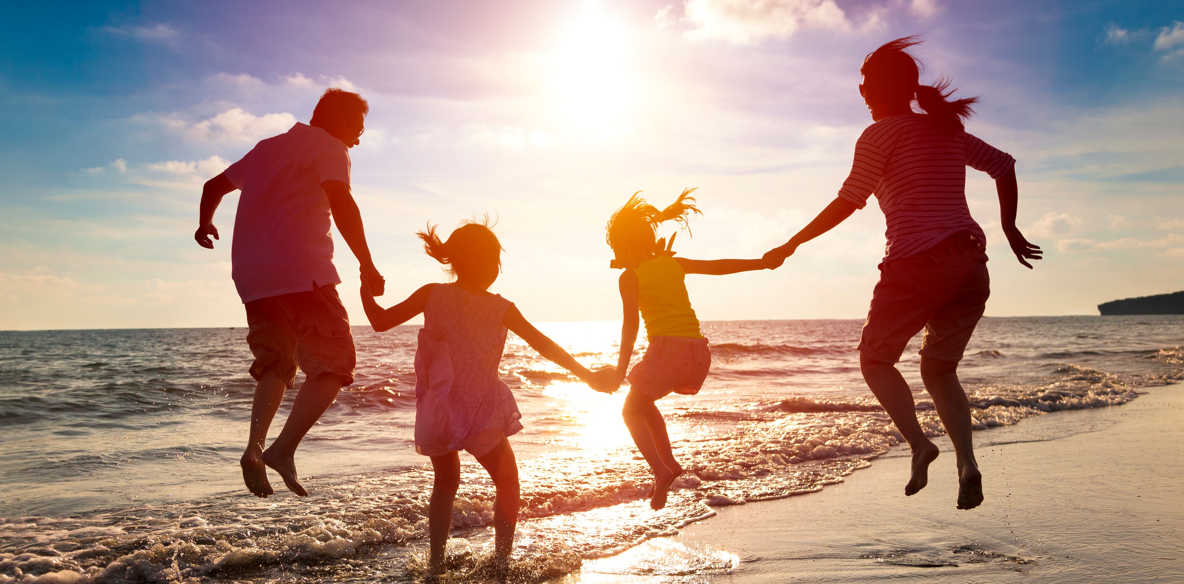 Familie springt zusammen am Strand