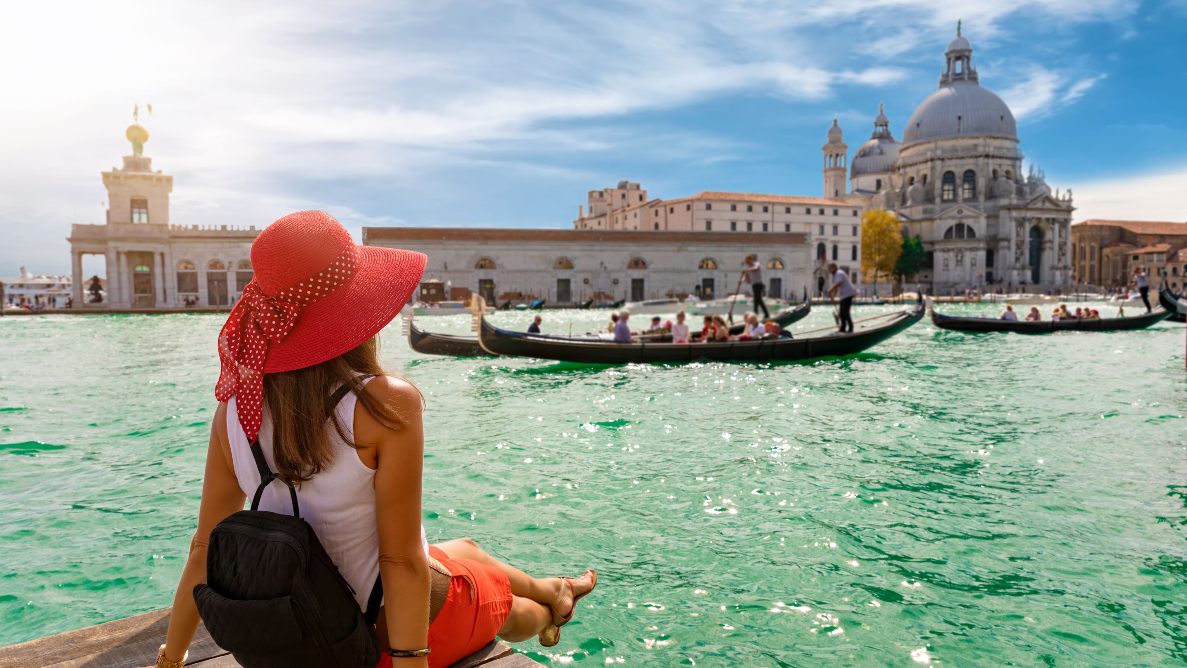 Frau sitzt in Venedig am Wasser