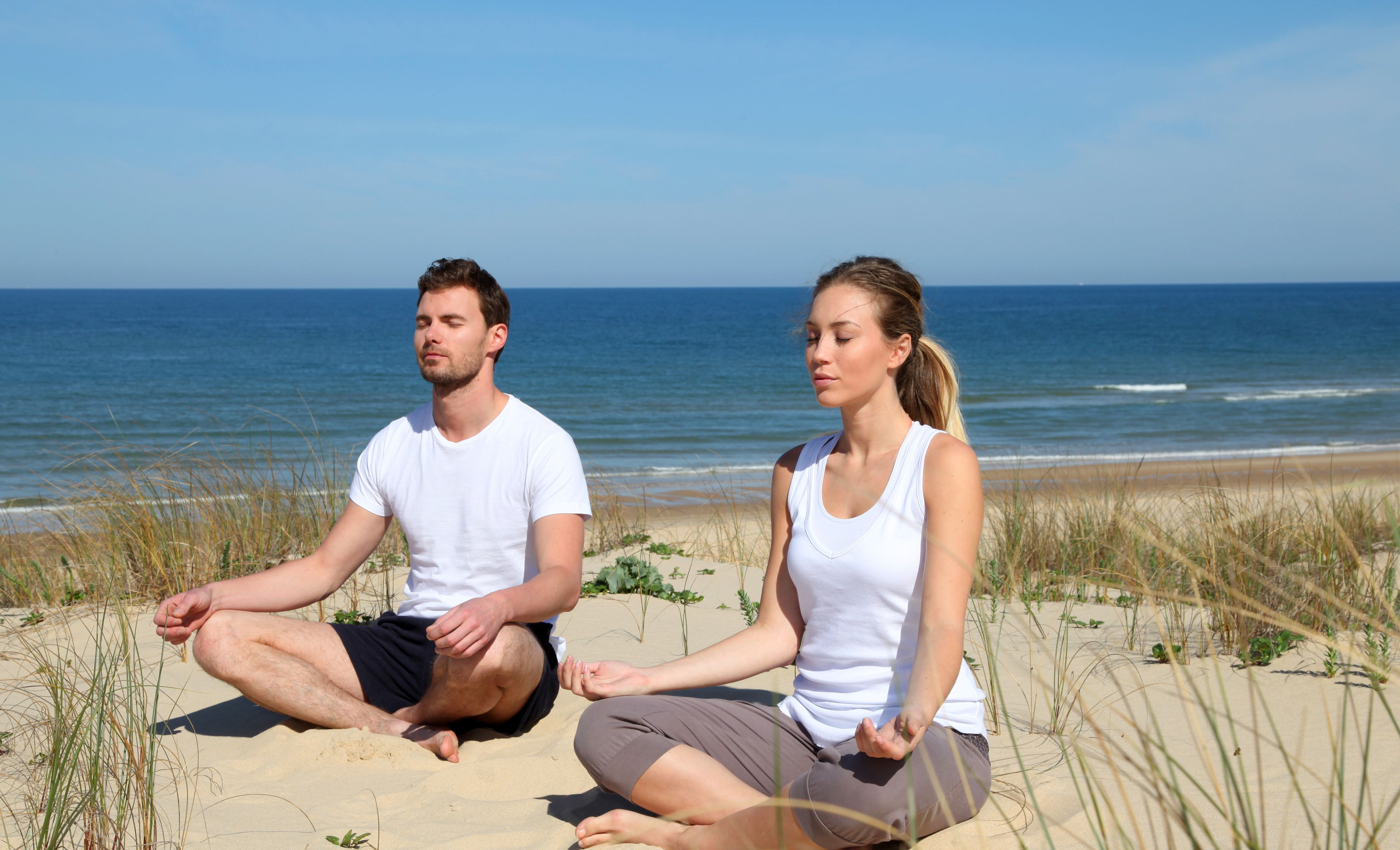 Paar macht Yoga an der Ostsee