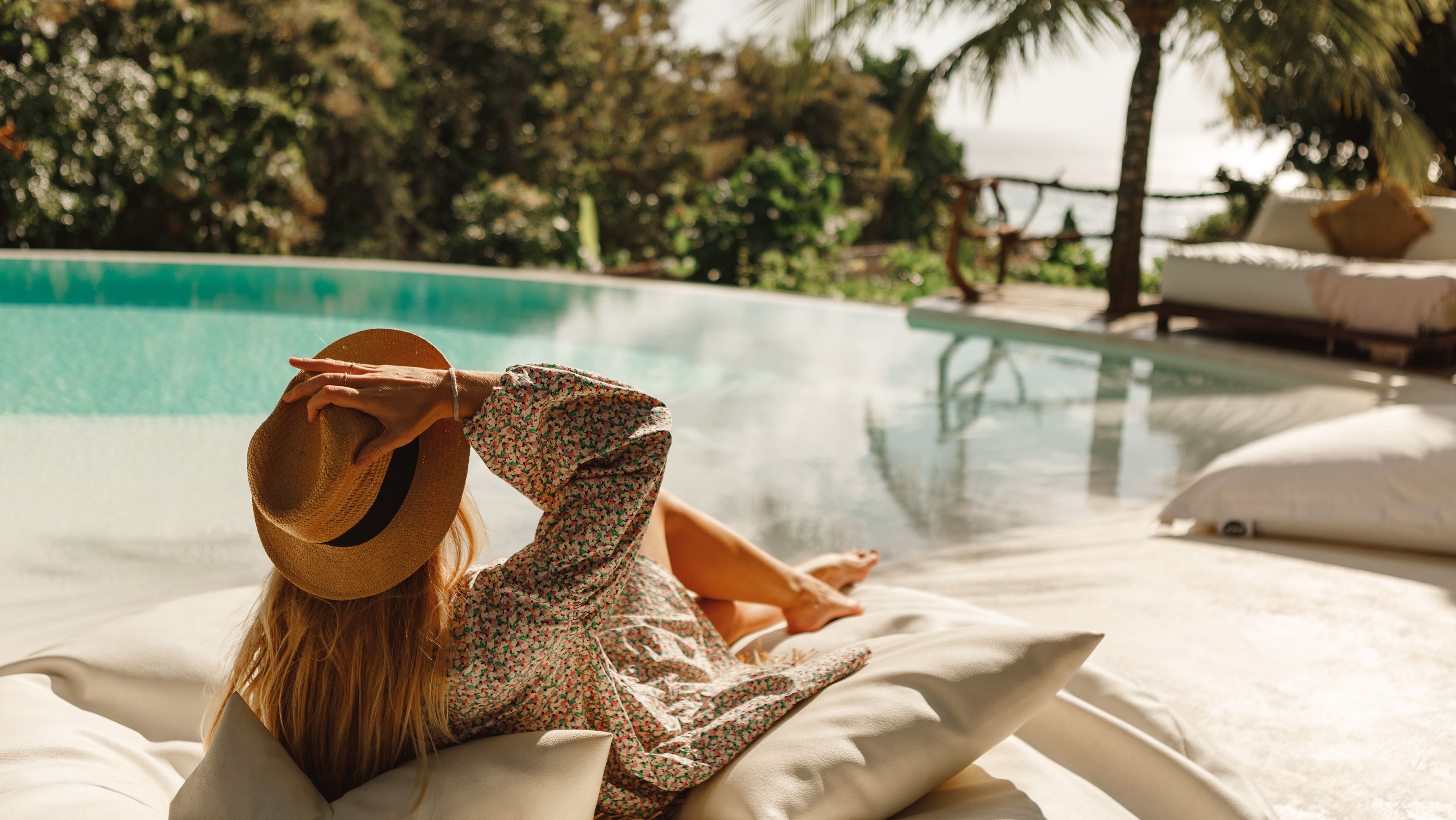 Eine Frau relaxt am Hotelpool während Ihrer Retreat Reise