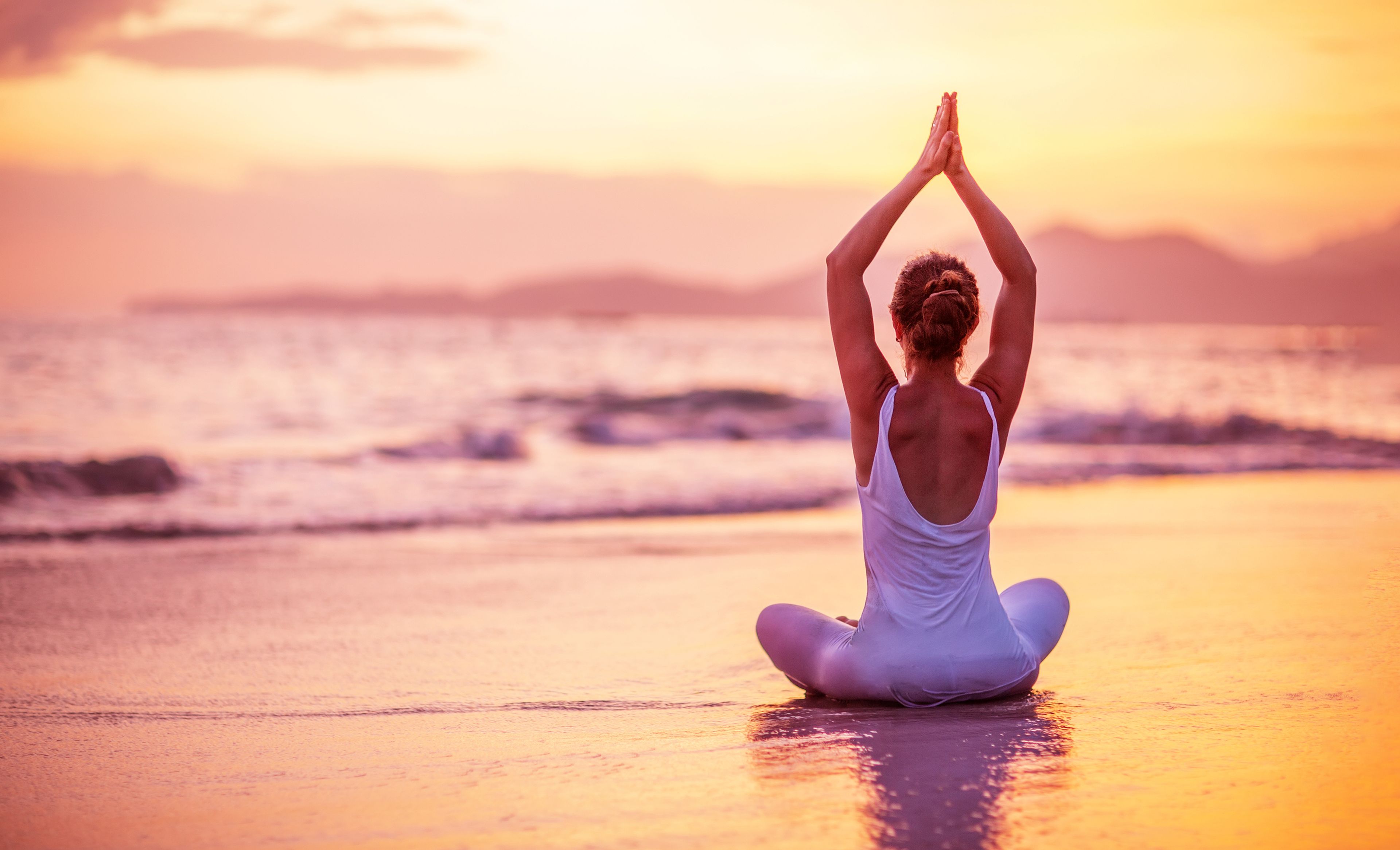 Frau macht Yoga Pose am Meer