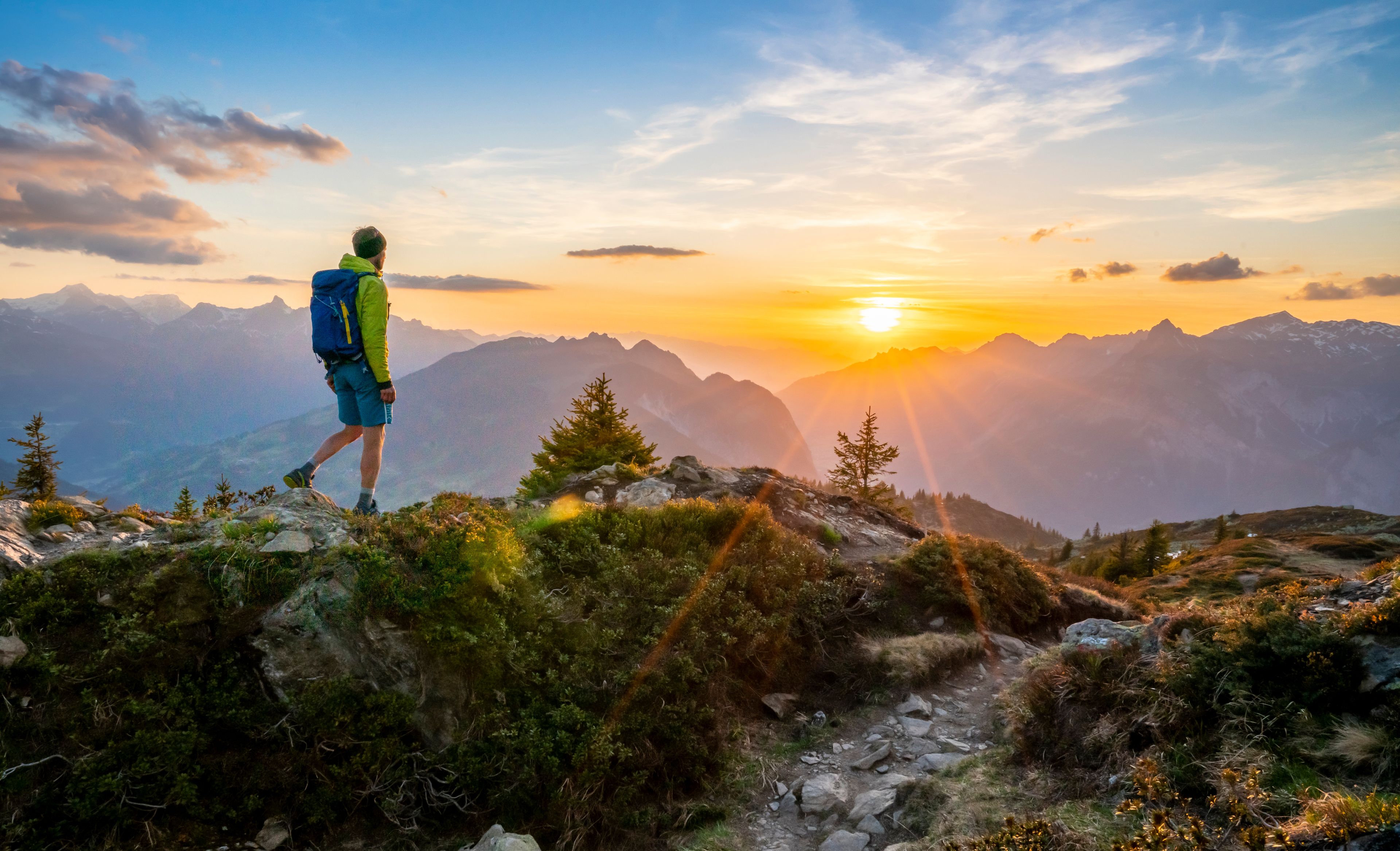 Mann beim Wandern in den Bergen beim Sonnenaufgang