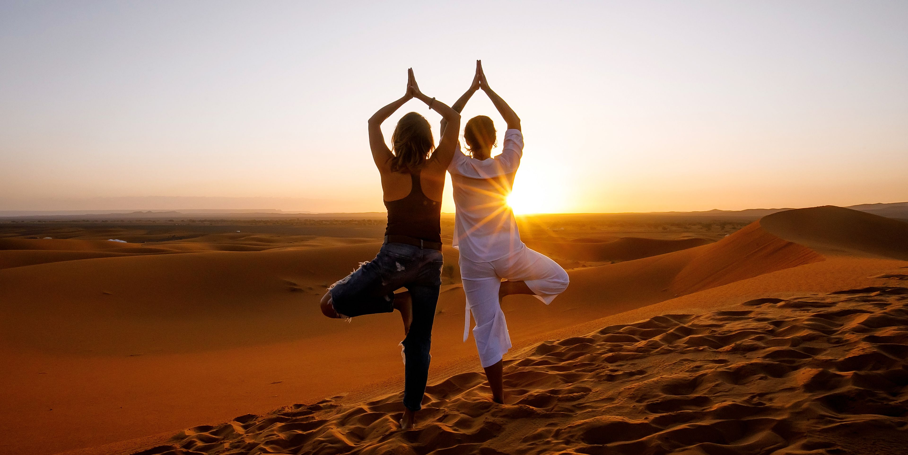 Zwei Frauen in Yoga Pose in der Wüste, Afrika