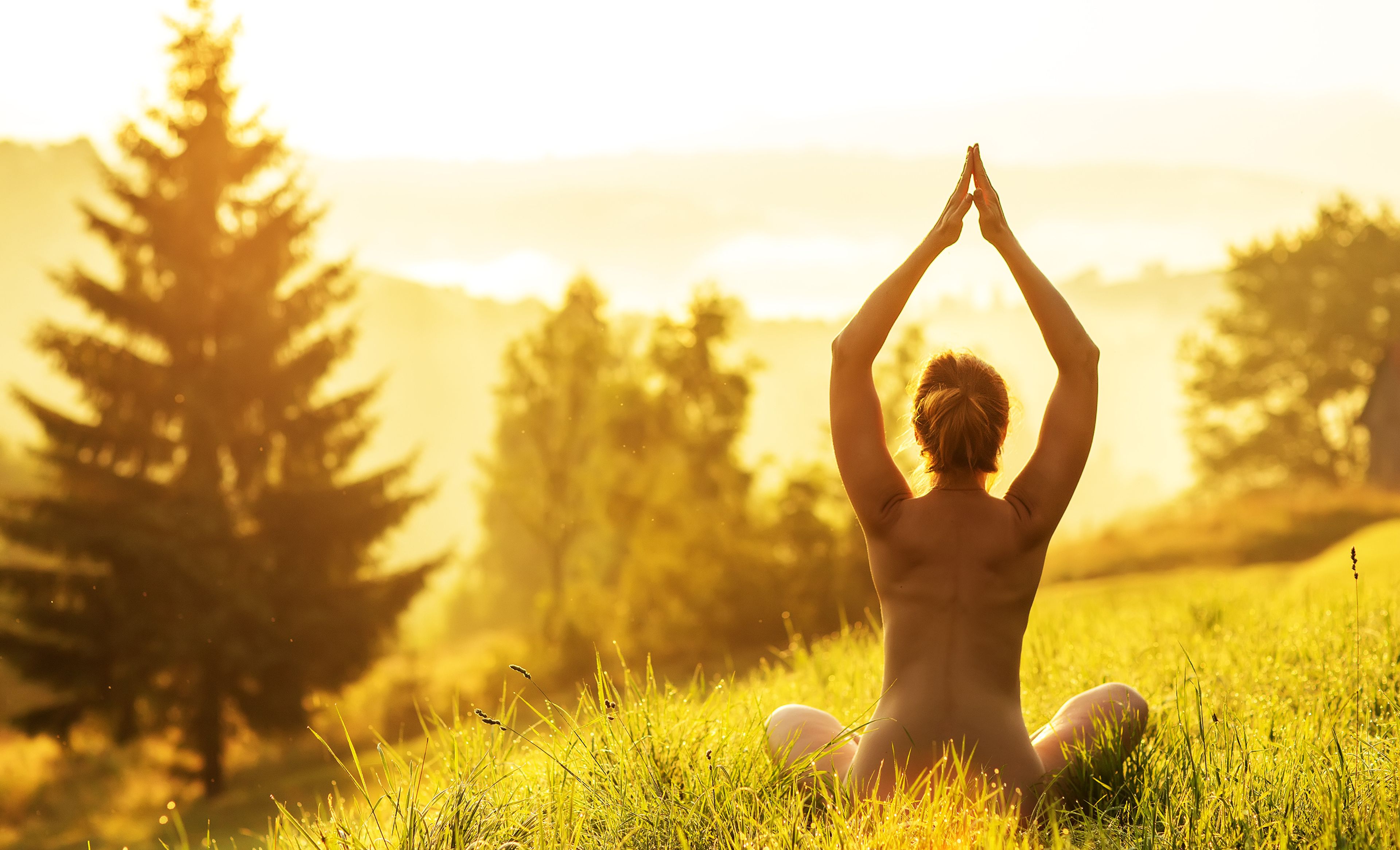Frau macht draußen nackt Yoga