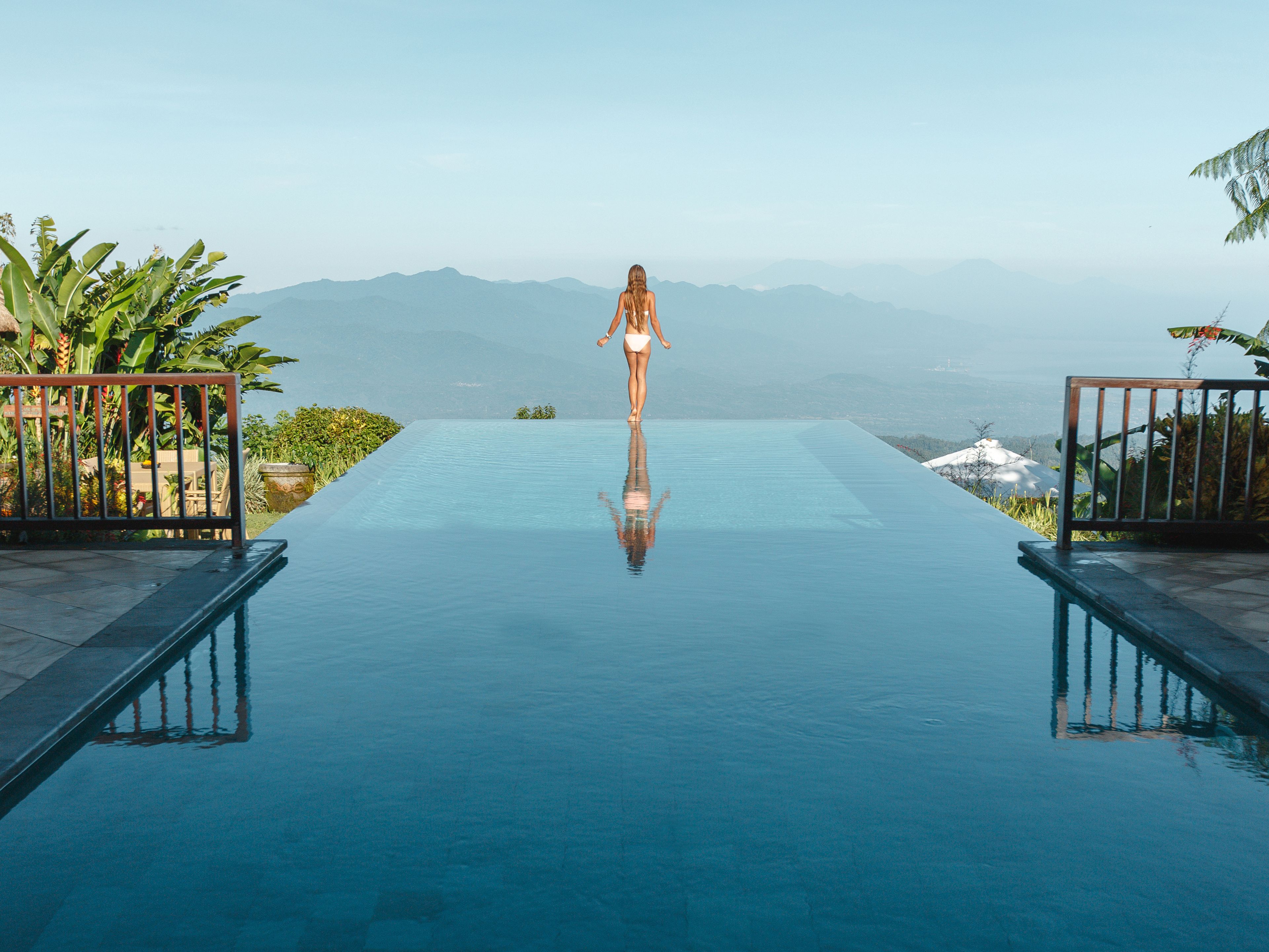 Frau entspannt im Infinity Pool auf Bali