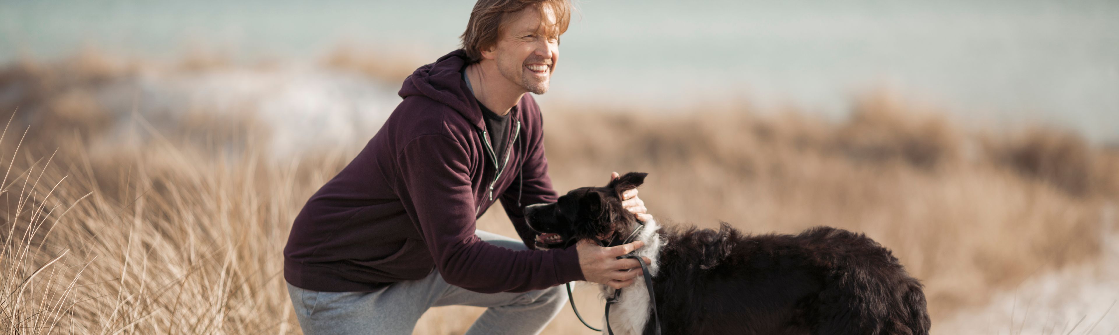 Mann mit Hund an der Ostsee