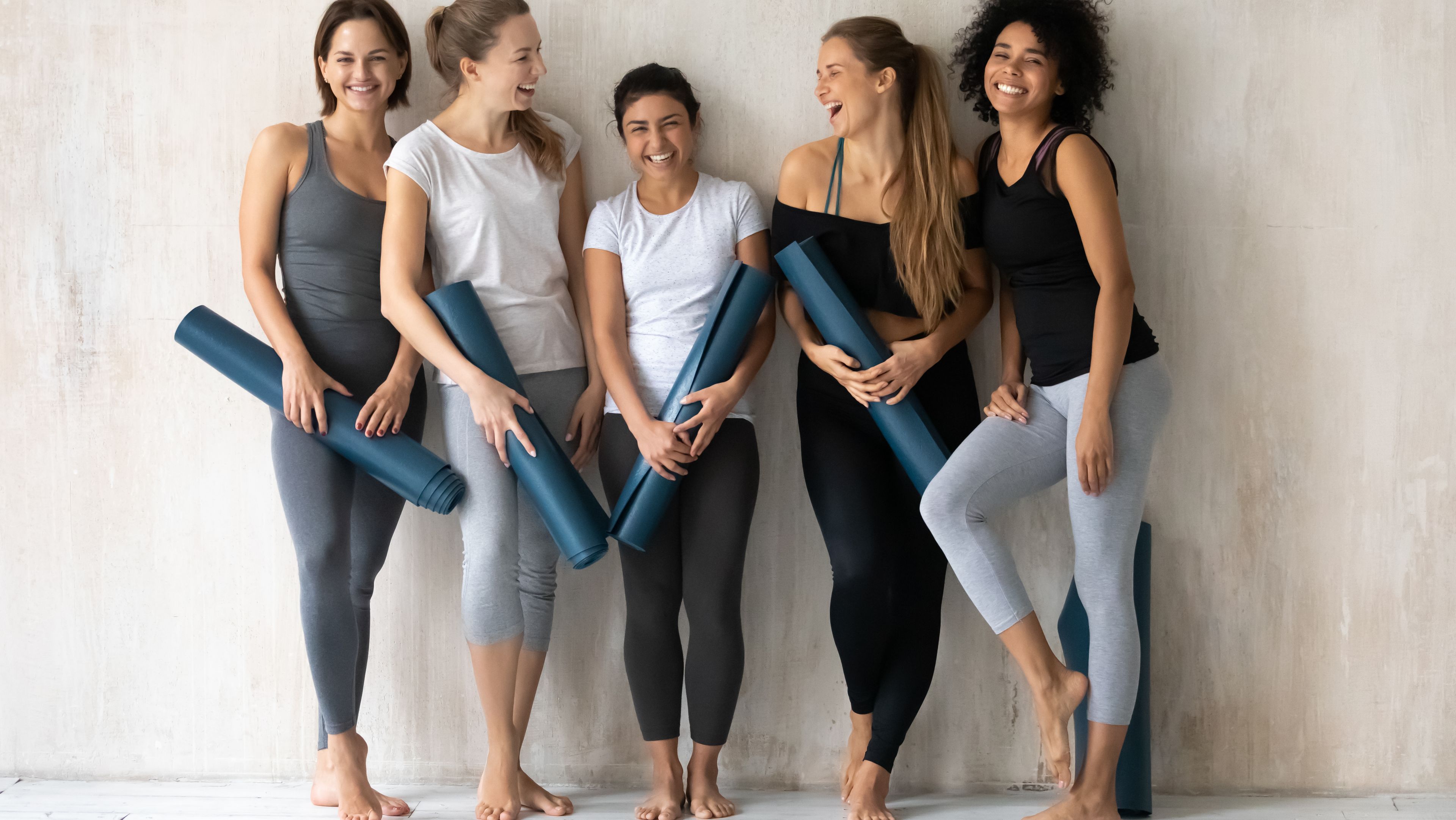 Frauen lachend mit Yoga Matten