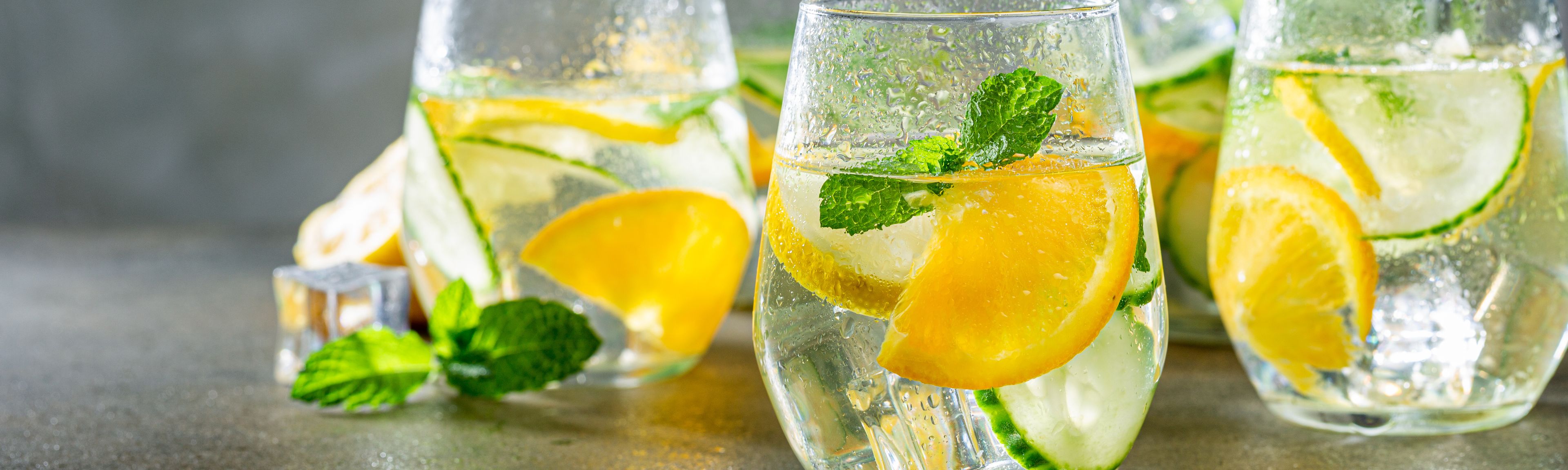 Gläser gefüllt mit Wasser und Zitrone sowie Gurke
