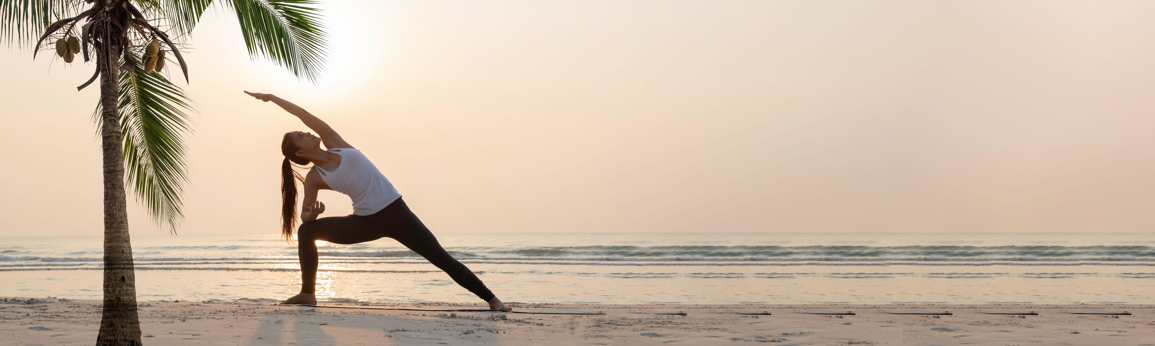 Frau in der Triangel-Yoga-Pose am Strand