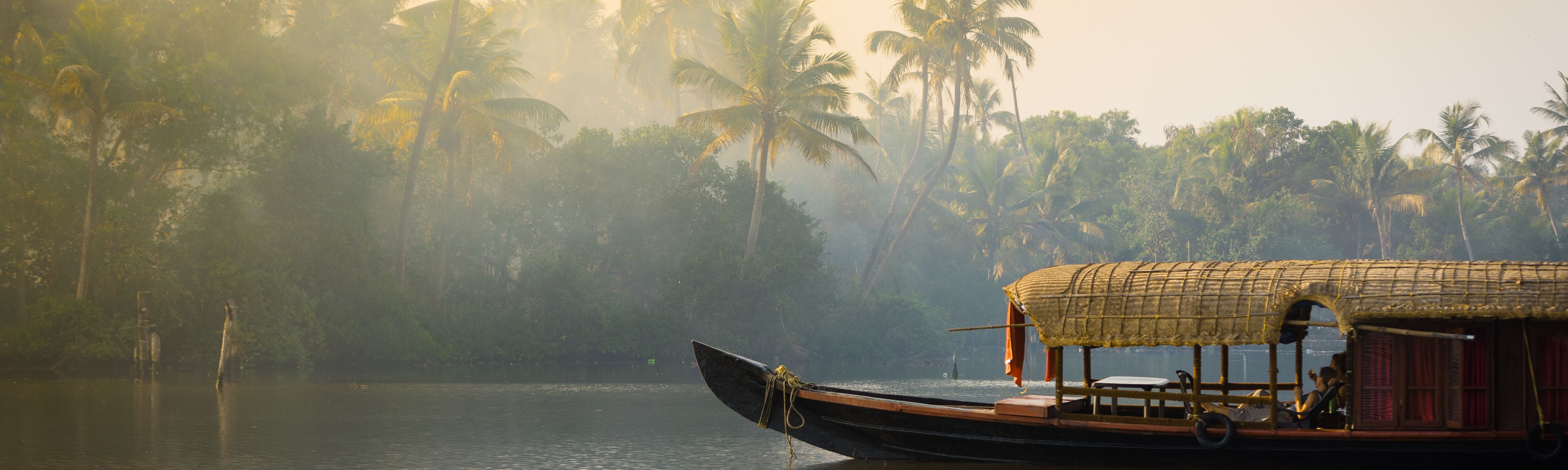 Ein traditionelles Hausboot ankert am Ufer eines Sees in Kerala