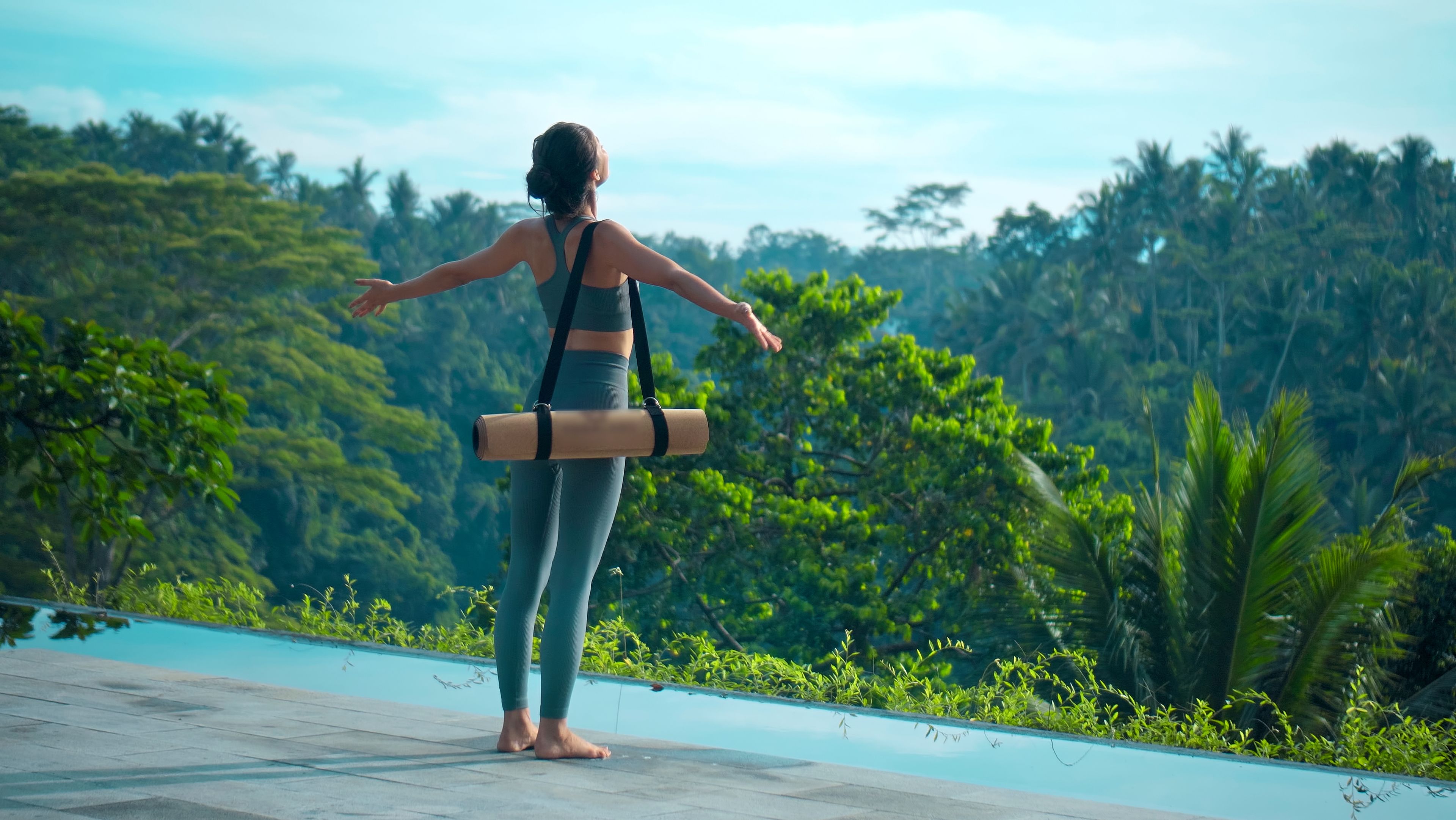 Frau mit Yoga Matte vor einem Dschungel