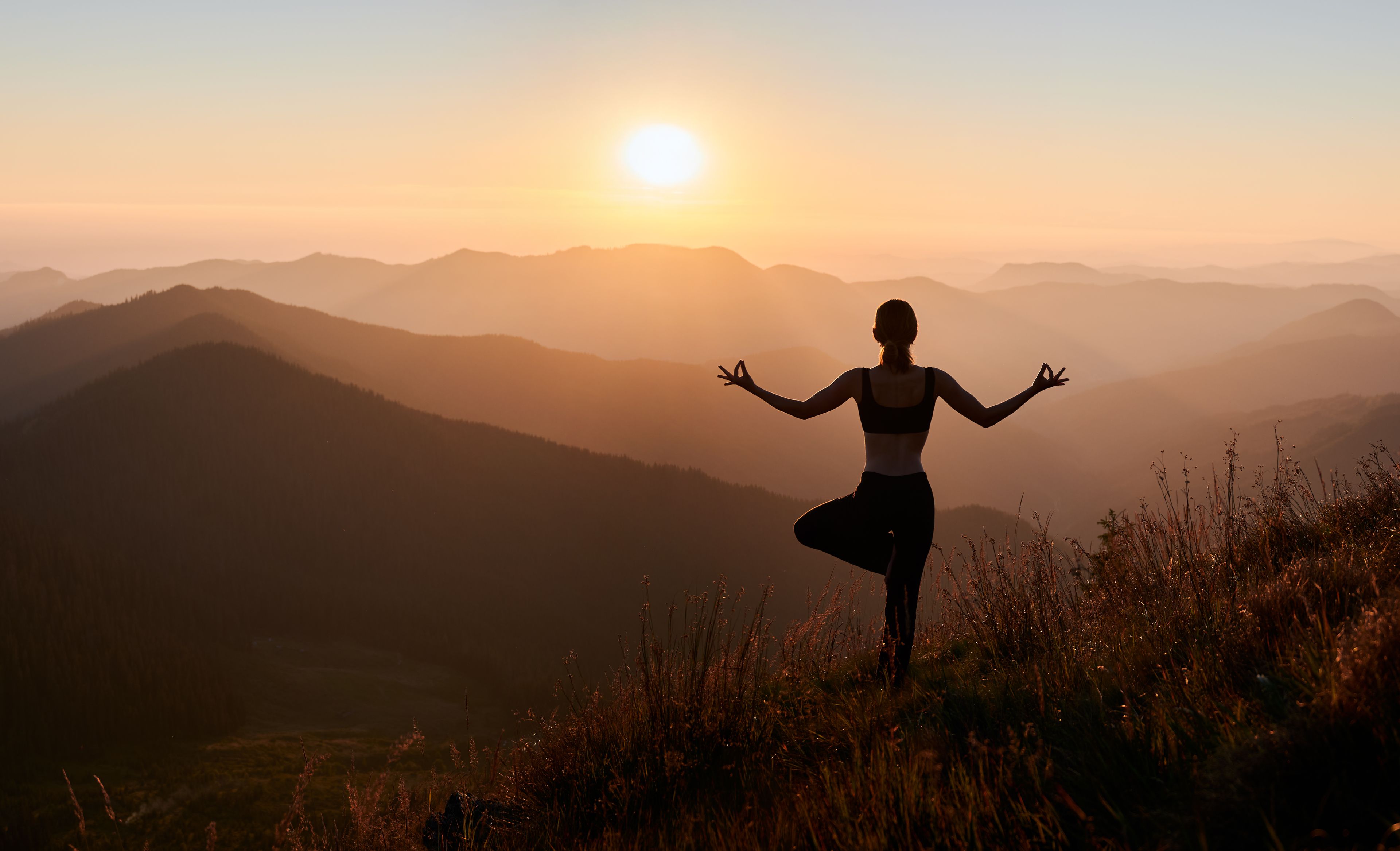 Frau in Yoga Posa in den Bergen