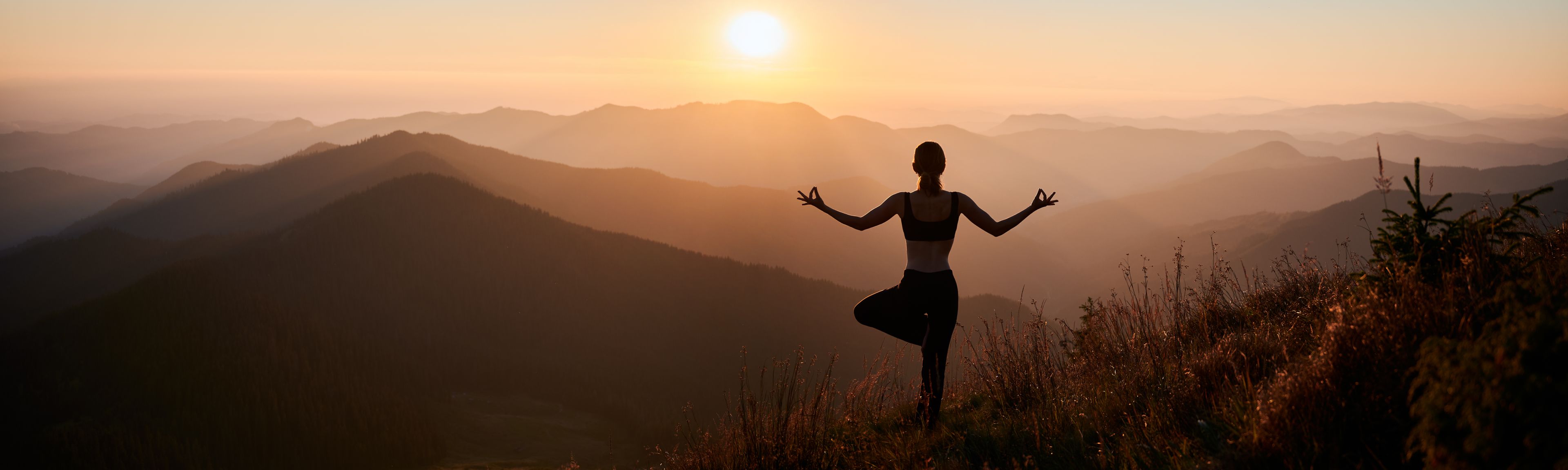 Frau in Yoga-Pose in den Bergen