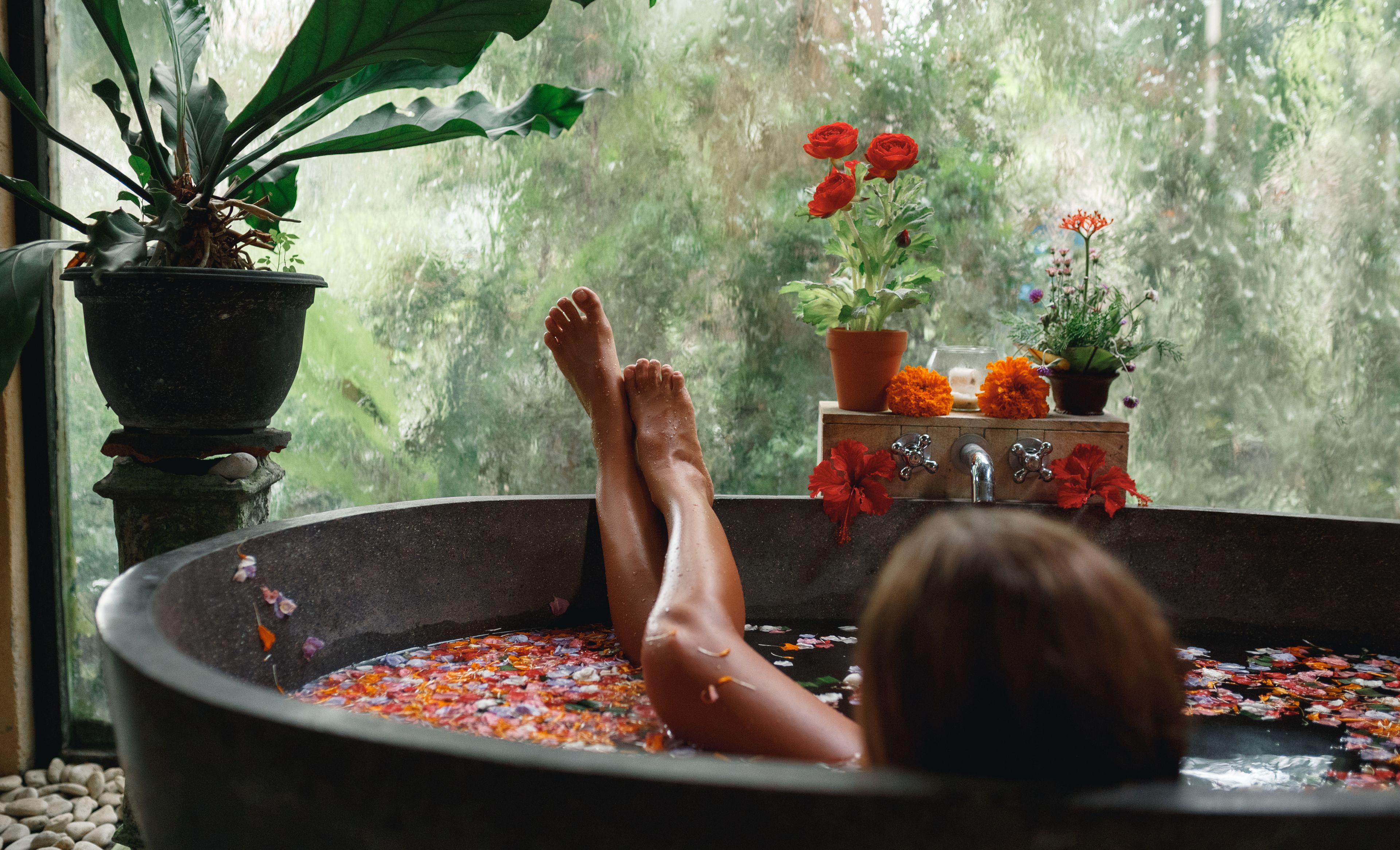 Eine Frau in einer mit Blüten verzierten Badewanne