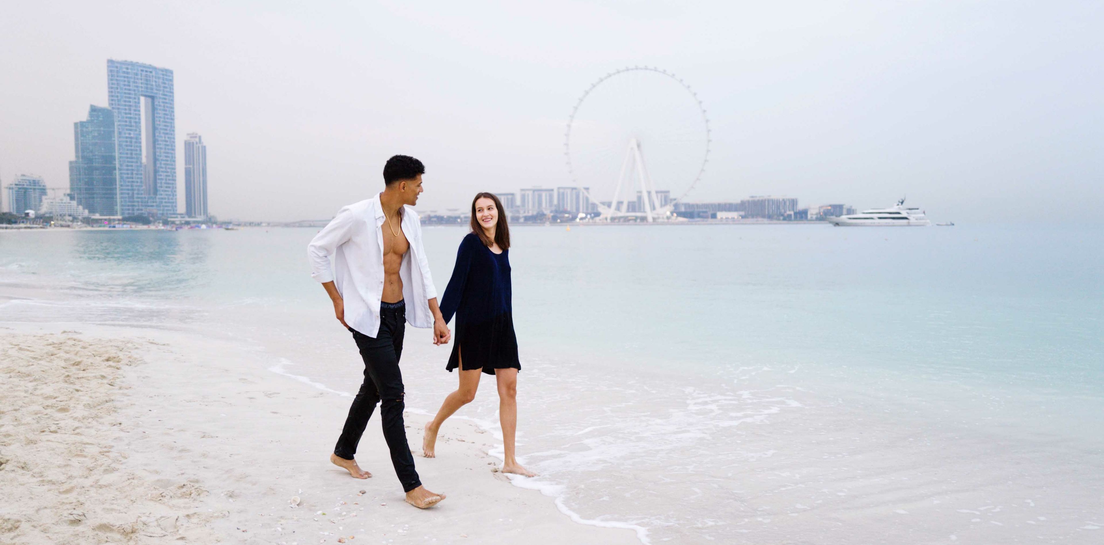 Paar läuft Strand in Dubai entlang