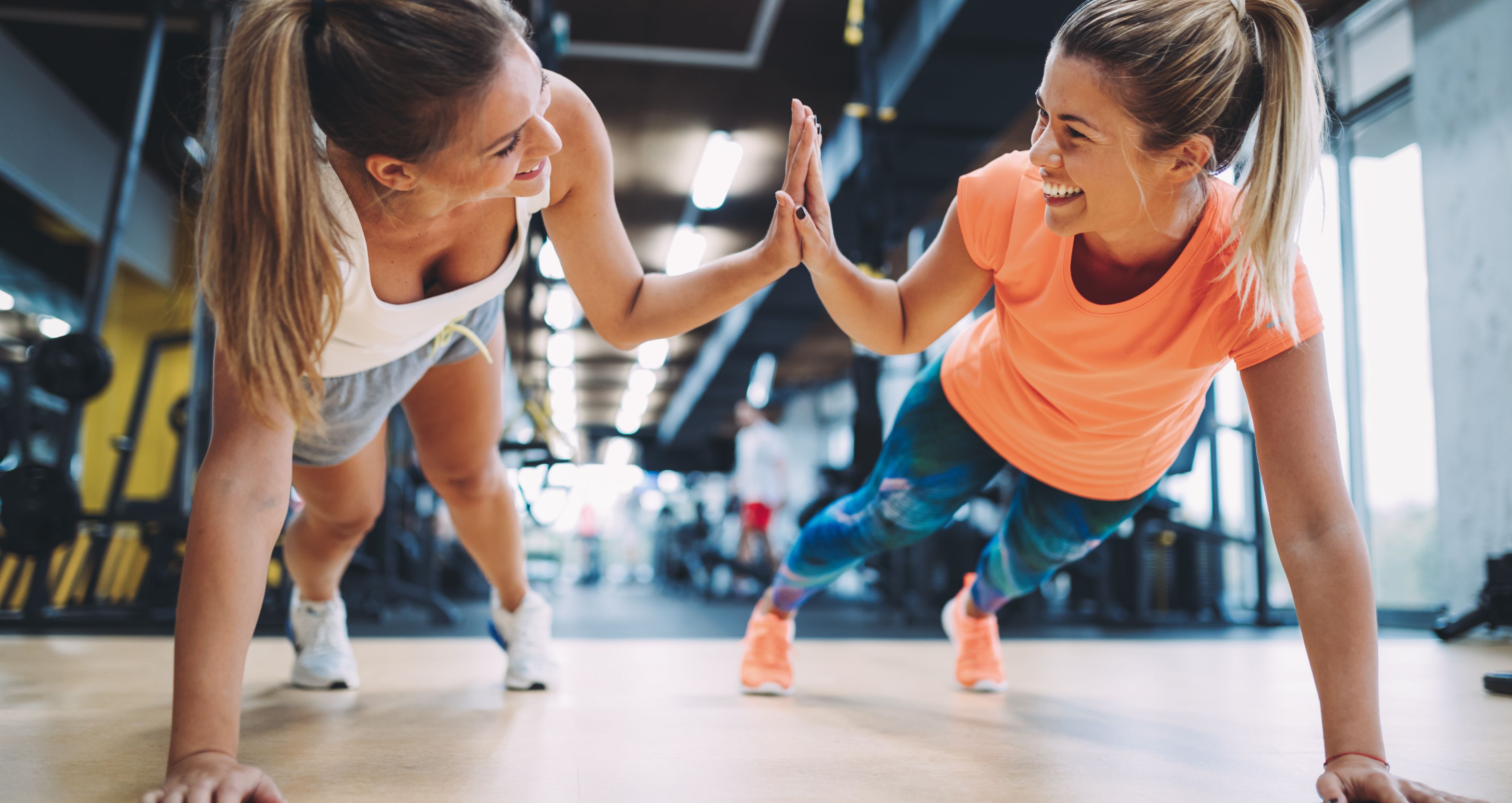 Zwei Frauen machen Fitness und lachen einander ins Gesicht