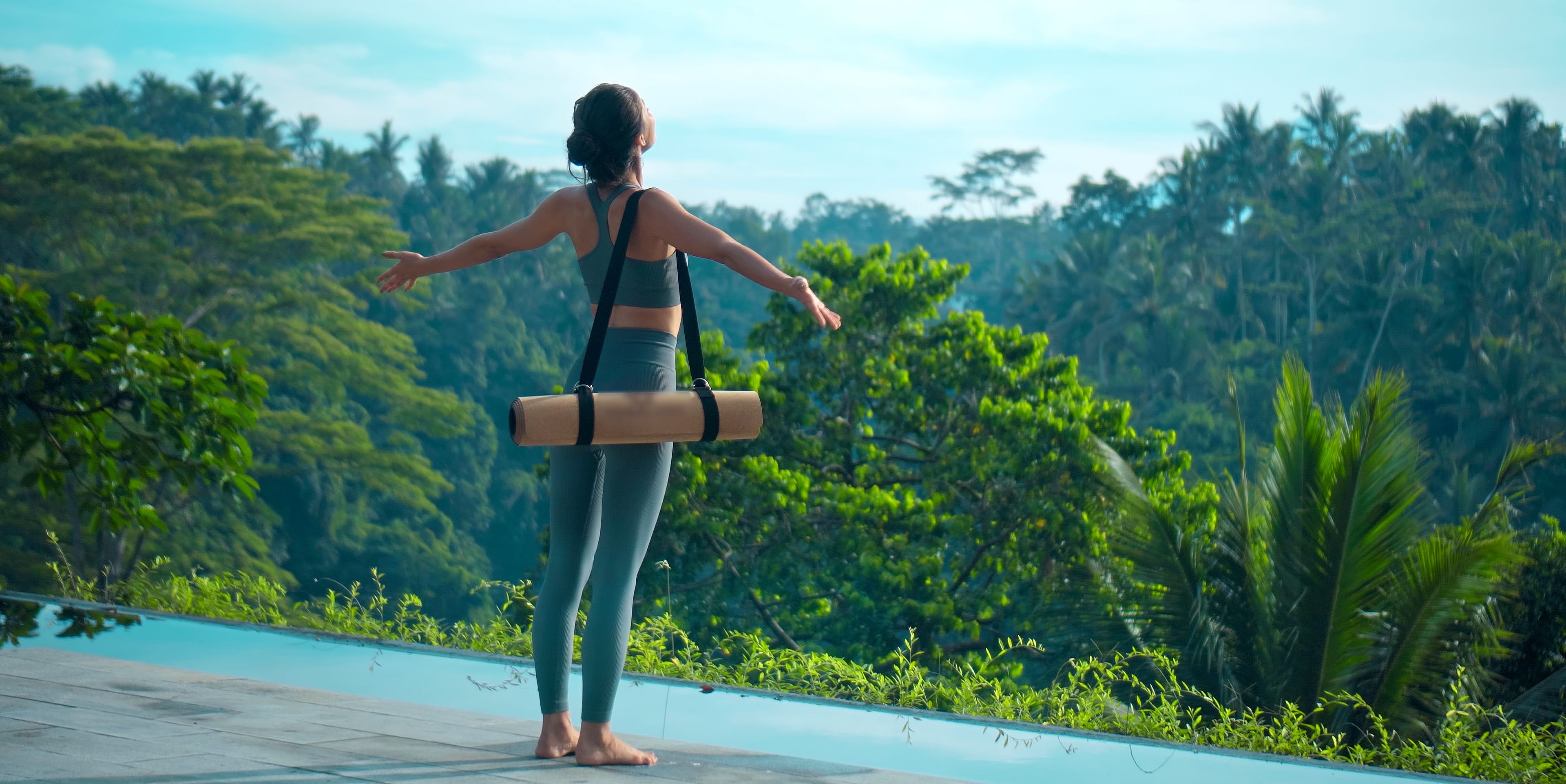 Frau steht mit ausgestreckten Armen vor einem beeindruckenden Dschungel Panorama 