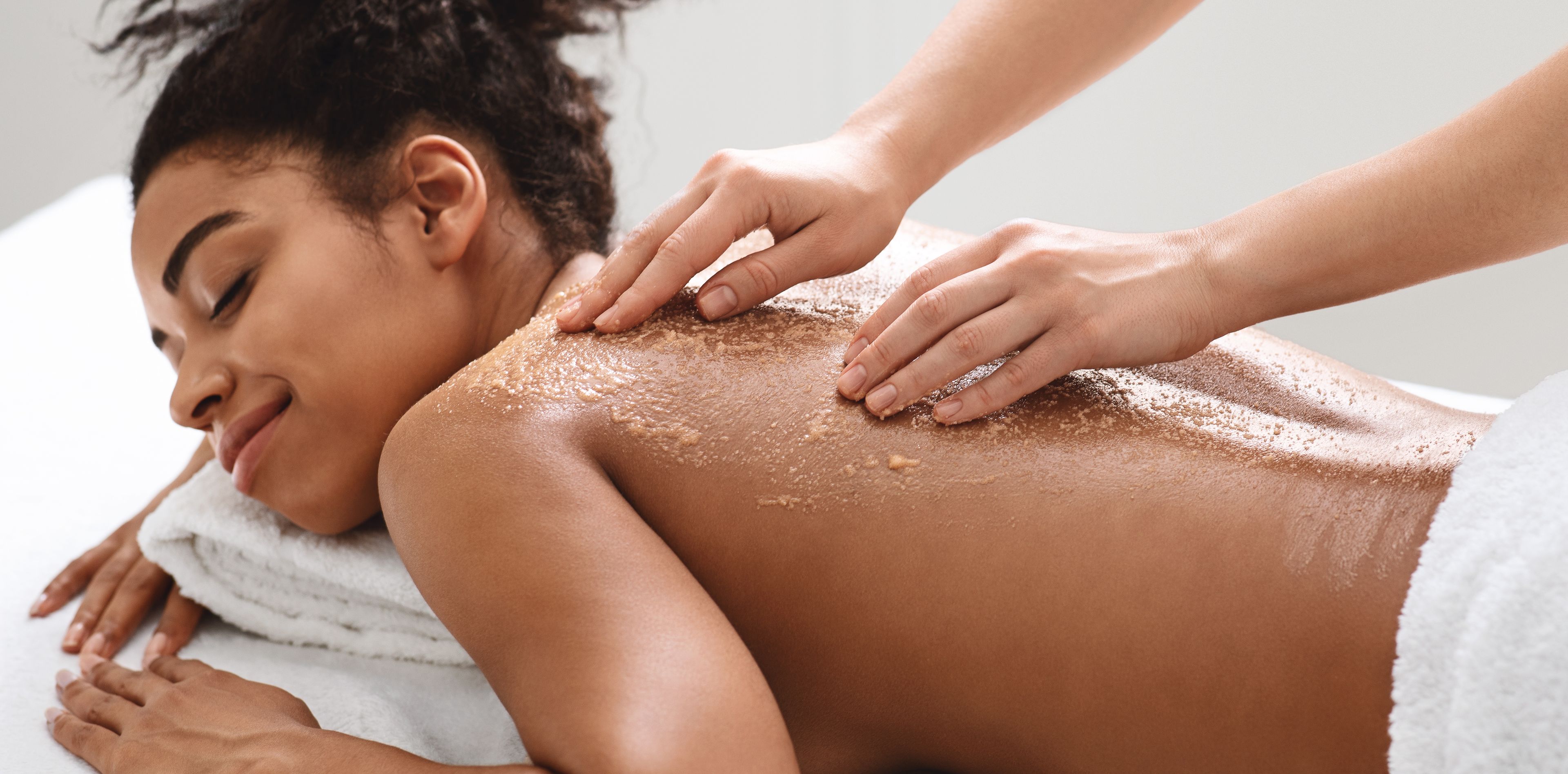 Una mujer haciéndose un masaje en la espalda