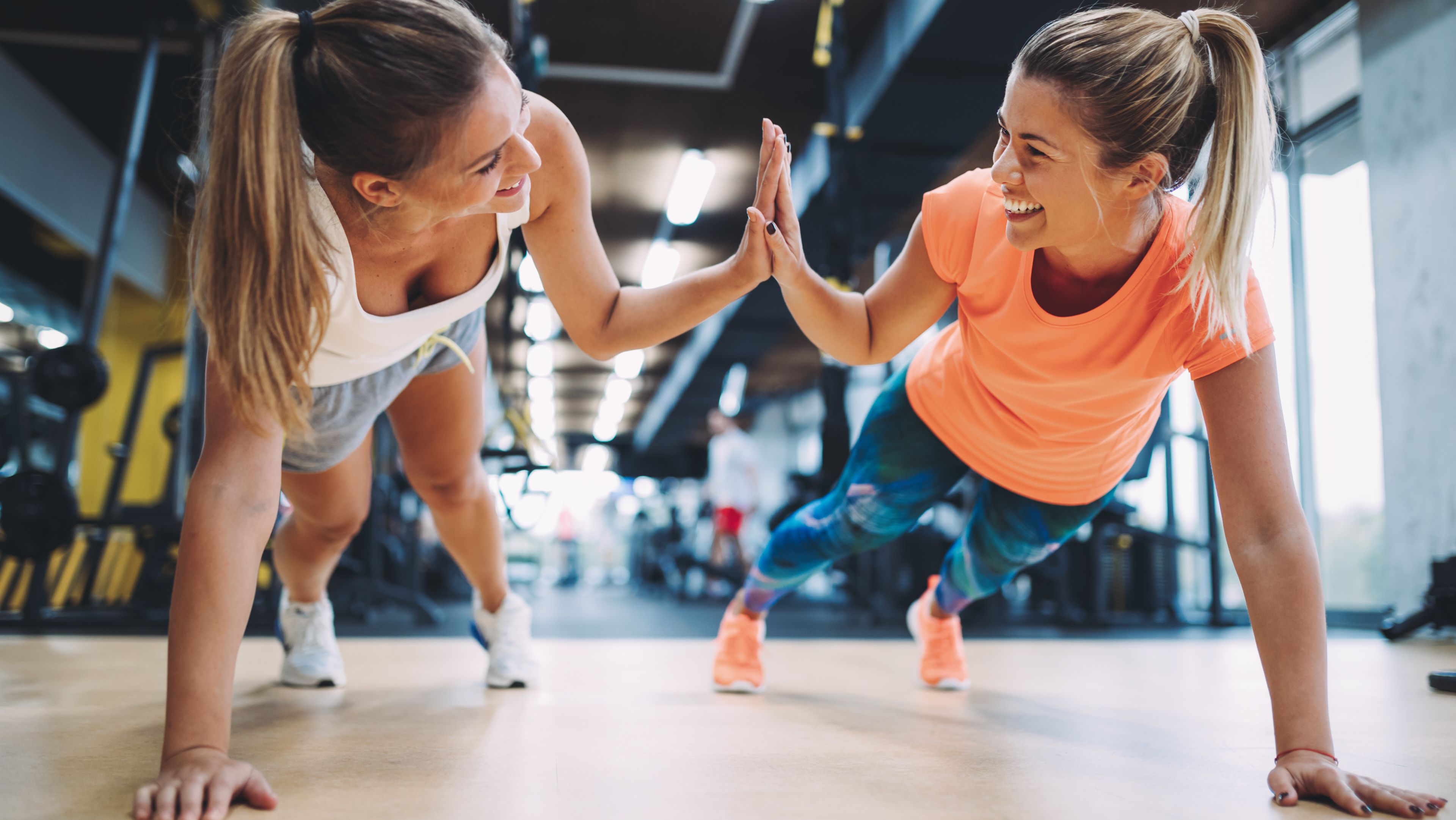 Zwei Frauen machen Fitness und lachen einander ins Gesicht