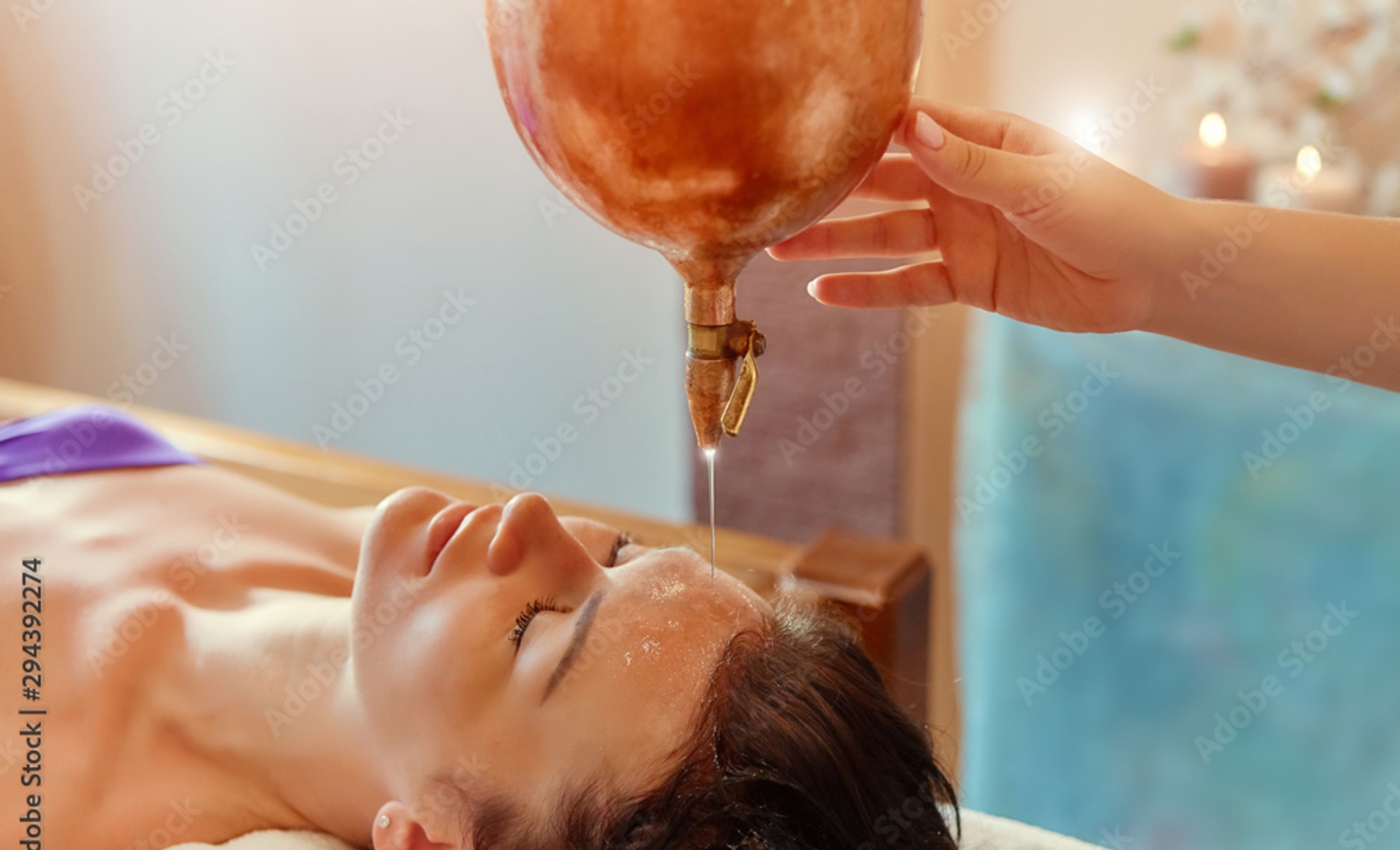 Frau bei einer Gesichtsbehandlung, bei der ihr Öl gegossen wird.