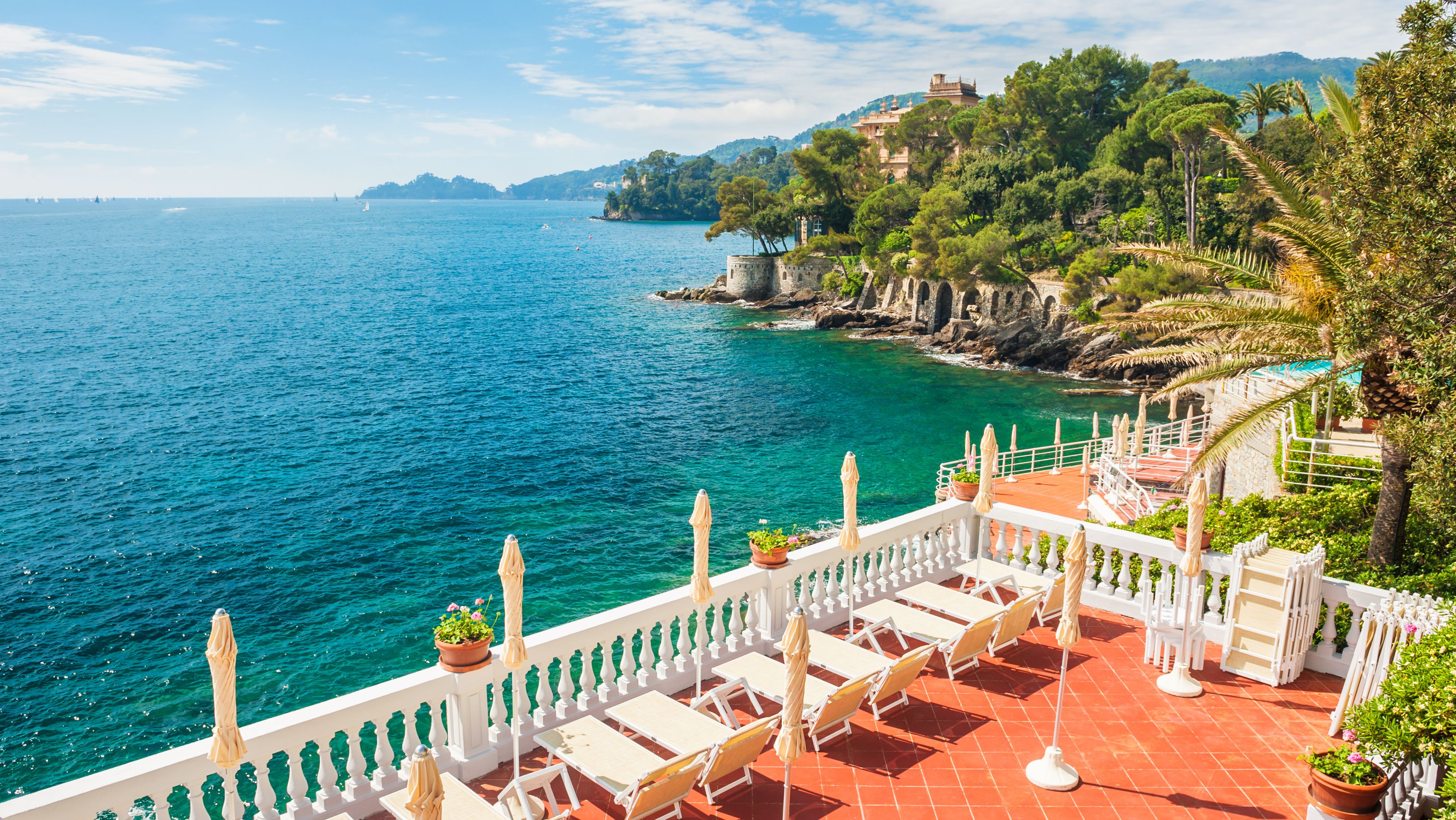 Hotelterrasse mit Liegen und Blick auf das Meer